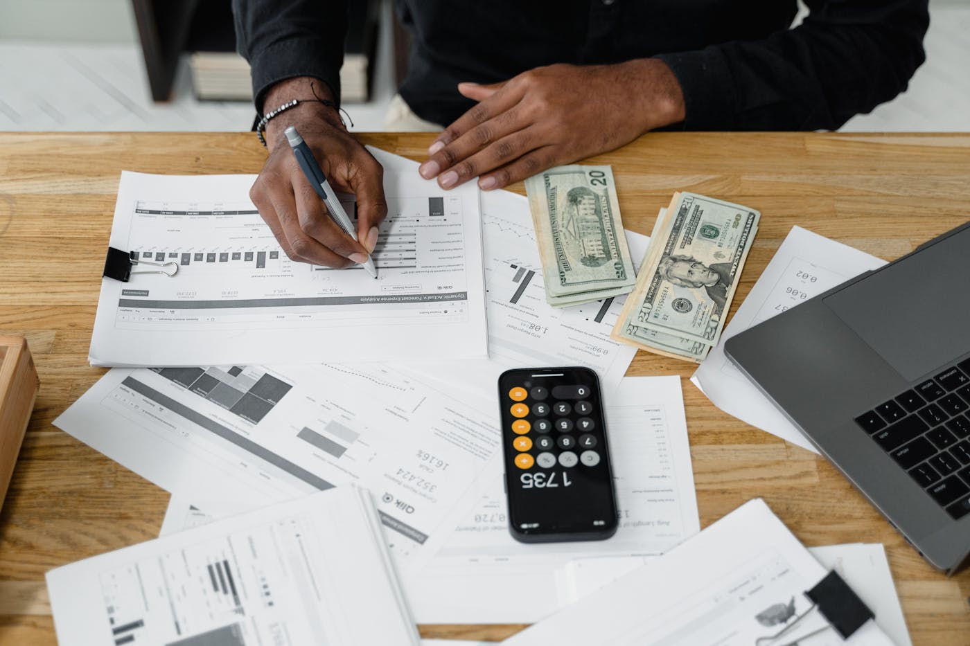 Financial workspace with laptop, charts, calculator, and reports