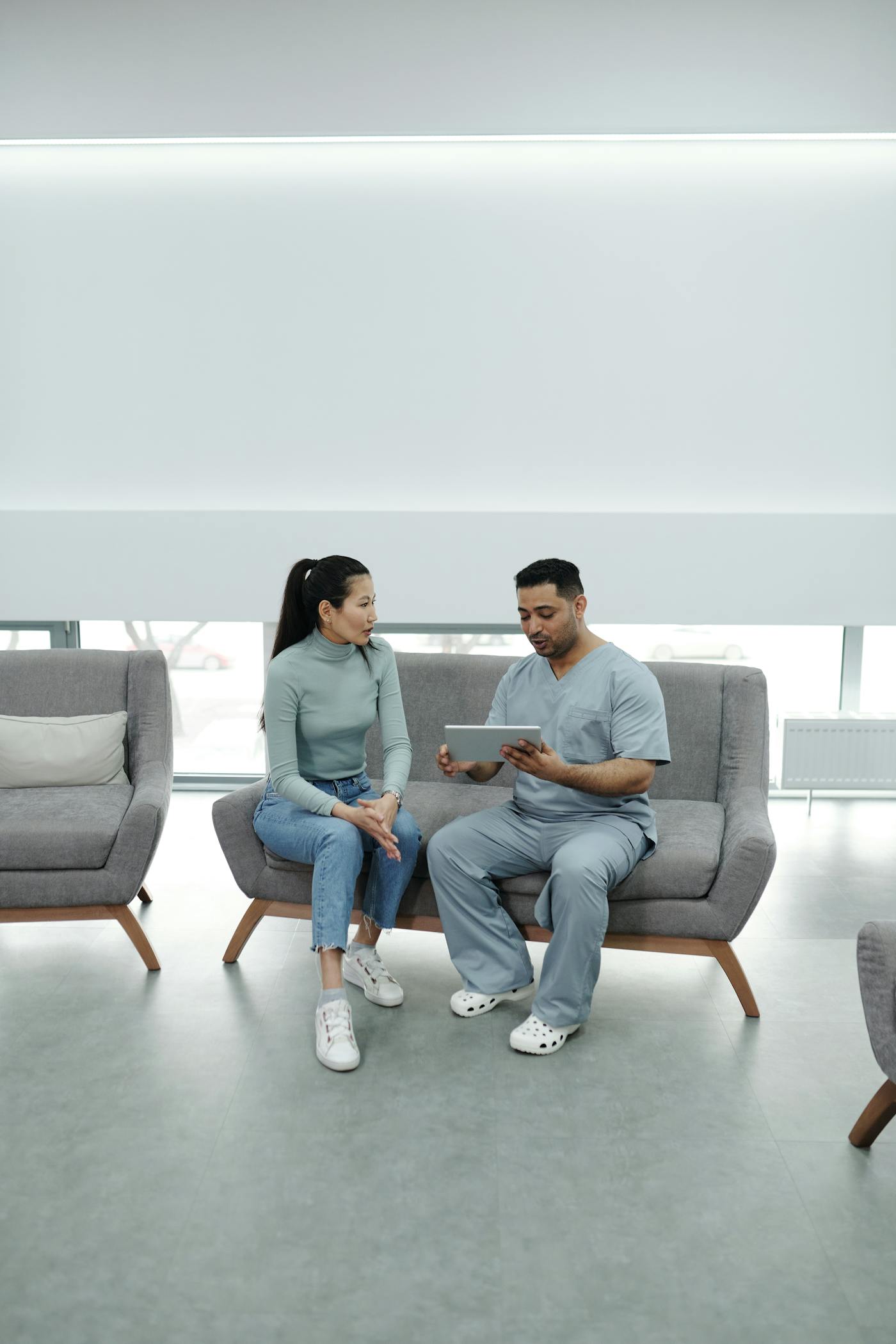 Doctor consulting with a patient while using a tablet