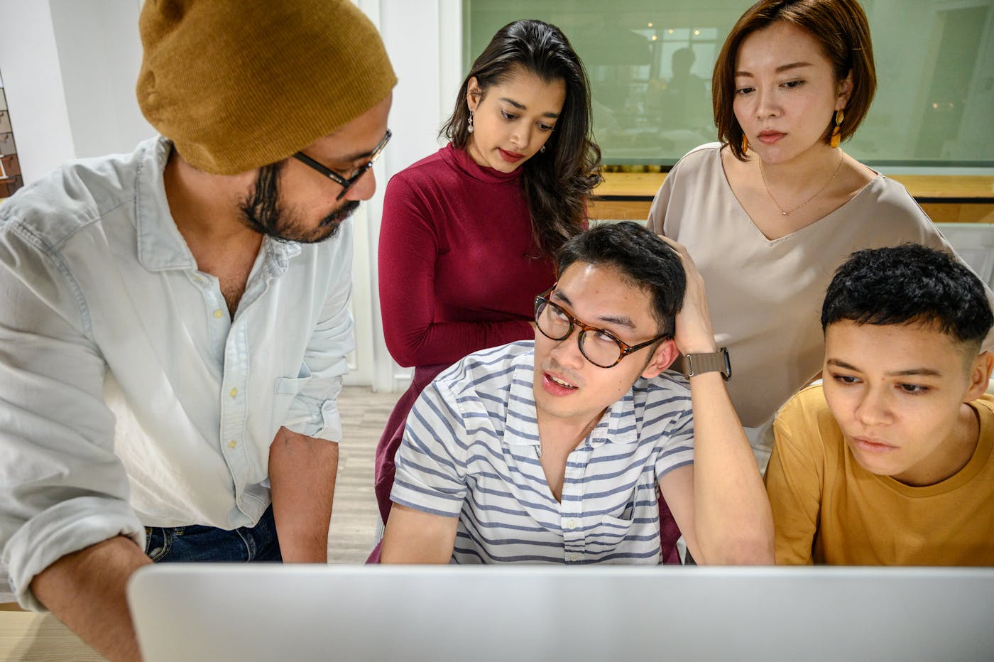 Professional team collaborating around a computer in an office
